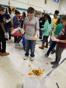 Elementary students sorting food waste in a school cafeteria